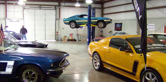 Classic cars in a shop with a BendPak two-post lift